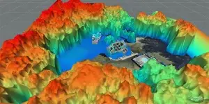 A 3D topographic map showcases a property with buildings nestled in elevated terrain, perfect for solar installations in Maine. Elevation ranges from red (high) to green and blue (low), illustrating diverse landscape heights ideal for optimizing solar energy efficiency.